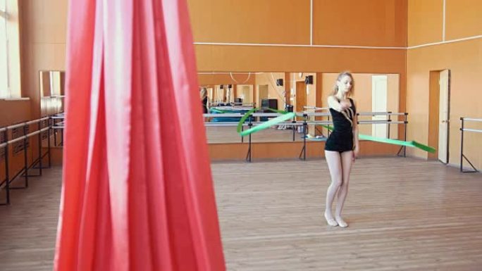 艺术体操-年轻女子用绿丝带训练体操