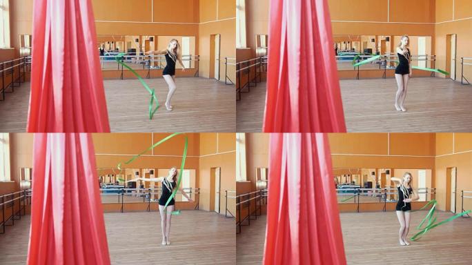 艺术体操-年轻女子用绿丝带训练体操