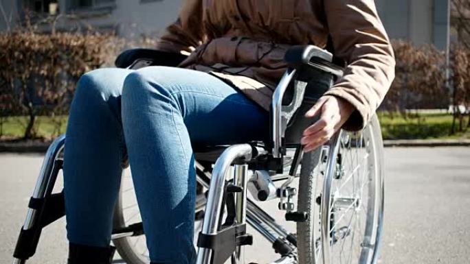 在城市公园的轮椅上有不同能力的年轻女孩