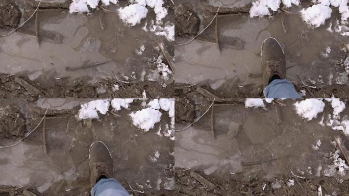 POV男人的脚在泥泞的水坑上破冰