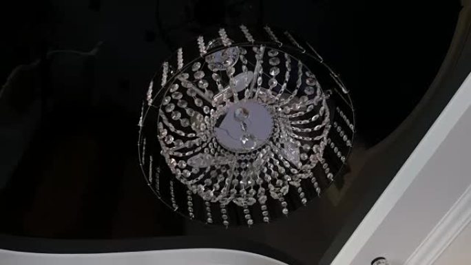 室内天花板上悬挂的美丽水晶吊灯圆形特写