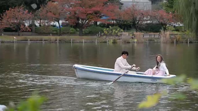 日本东京秋天上野公园的年轻夫妇划船