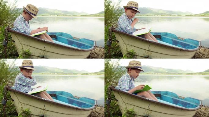 男孩坐在停泊在河岸的木船上看书