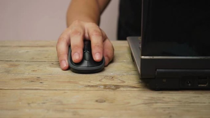 商人用手指点击和旋转滚轮鼠标控制笔记本电脑