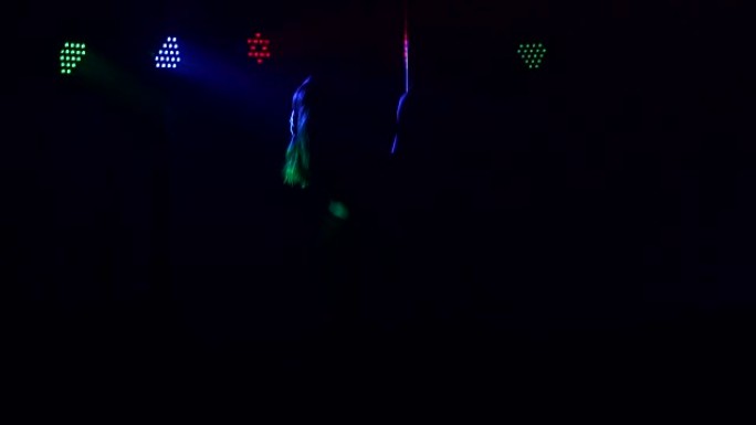 一个性感女孩在钢管上跳舞的剪影。