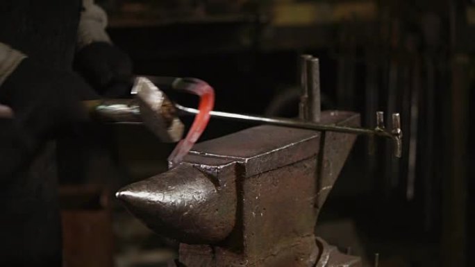铁匠正在熔炉的铁砧上敲打加热了的金属坯