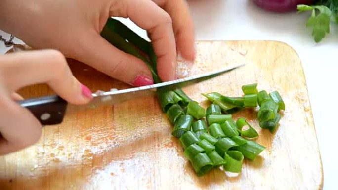 豆芽，葱。健康饮食的概念。年轻女子用刀切葱