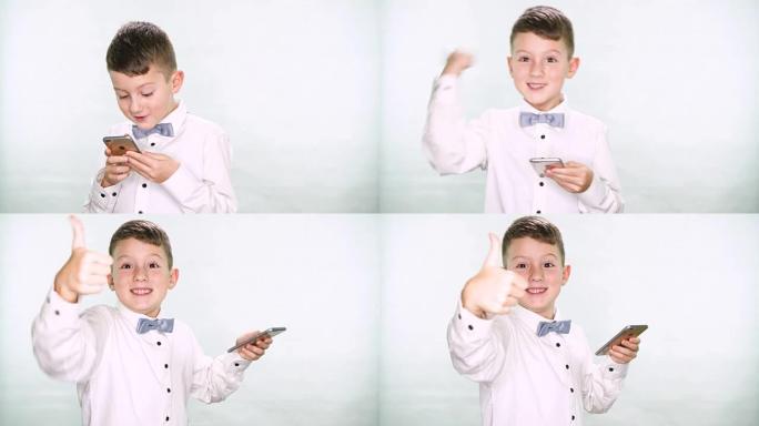 男婴竖起大拇指，在白色背景上玩平板电脑或智能手机