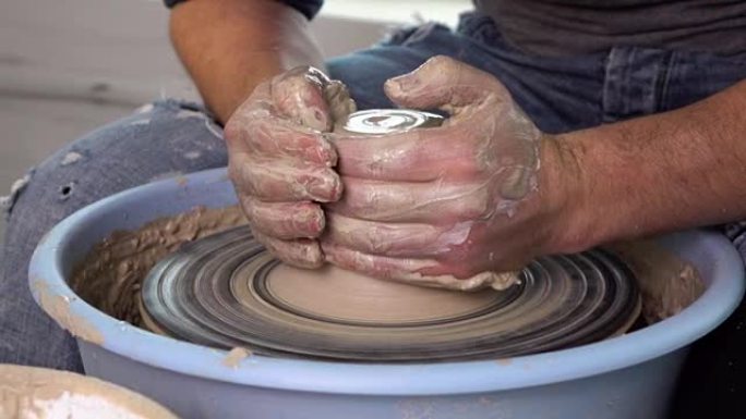 陶工在陶工的轮子上做了一个花瓶。慢动作