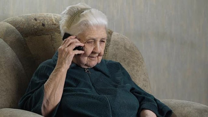 老年妇女在手机上聊天。