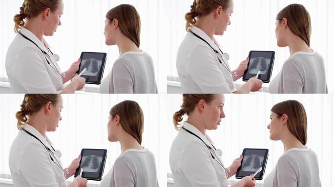 女医师在门诊给女性病人展示平板x光片。工作中的女专业医生