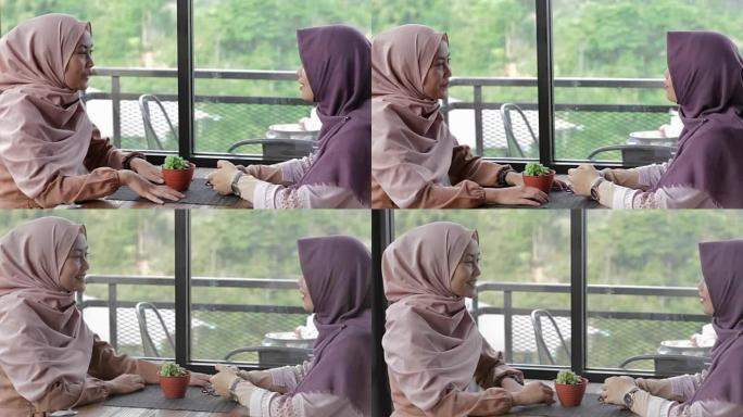 两名美丽的穆斯林妇女在咖啡馆聚会，经过编辑和原始