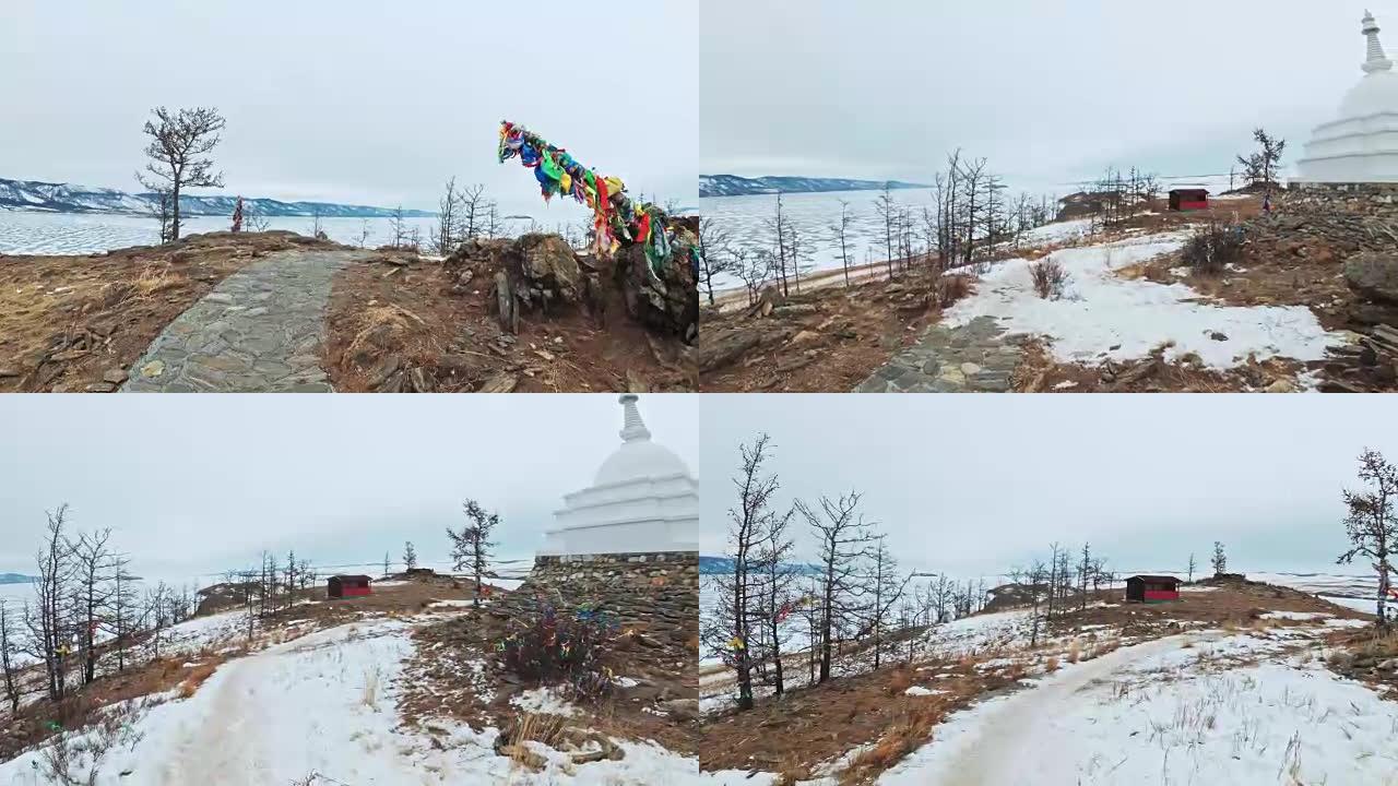 女人在贝加尔湖冰上的旅行。视点视图。关闭独特的佛教佛塔布尔汉纪念碑象征神秘的历史仪式岛Ogoi景观山