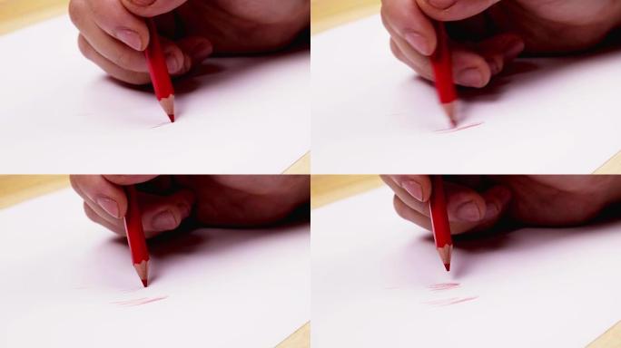 手握一支红色铅笔在白色的桌子上