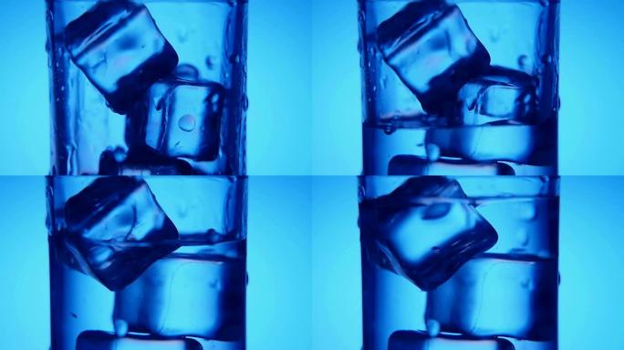 玻璃中的蓝色冰块和充满气泡的水