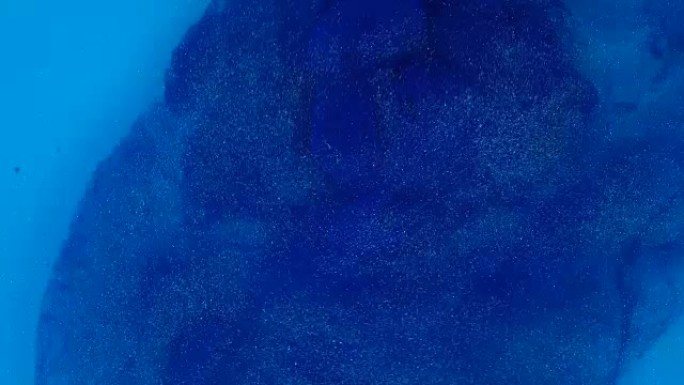 4k镜头。水中墨水。蓝色墨水在水中反应产生抽象背景。