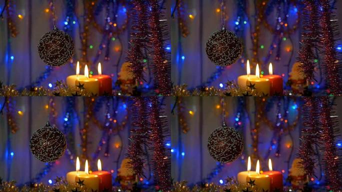 一个大红色的球。新年和圣诞装饰品。燃烧蜡烛。闪光花环。背景模糊。