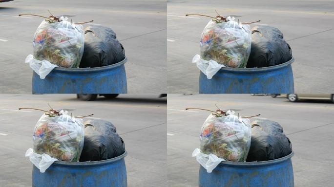 装满大垃圾袋的垃圾桶装满了剩余的食物和垃圾在街上