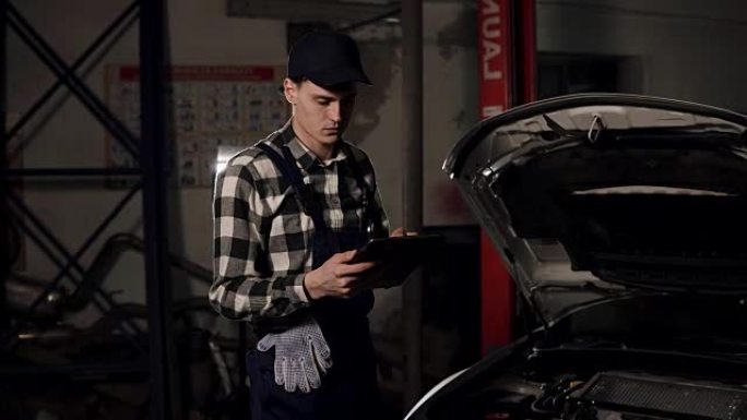 汽车维修技术人员使用数字平板电脑检查车辆内部。汽车维修，保养，人的概念。