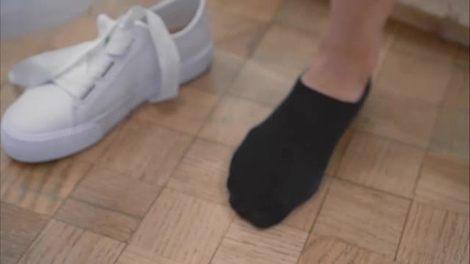 一名年轻女子在商店里用白色运动鞋绑上鞋带。特写