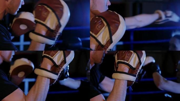 女运动员训练她的拳击袋，这是由她的搭档，教练。强壮漂亮的女人在健身房锻炼。