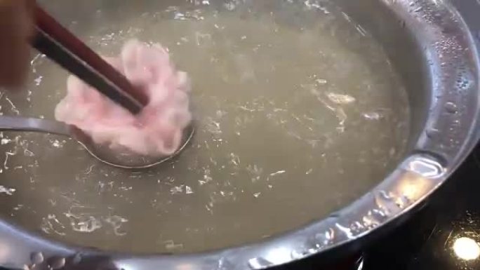在火锅中煮沸的切成薄片的猪肉