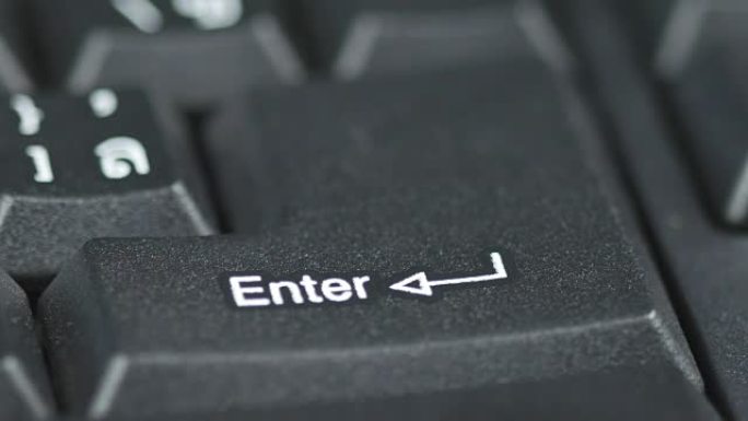 人体手指按下电脑键盘上的输入按钮的特写