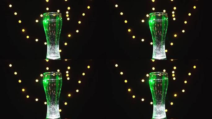 绿灯中的一杯水在旋转。绿色鸡尾酒。酒吧概念