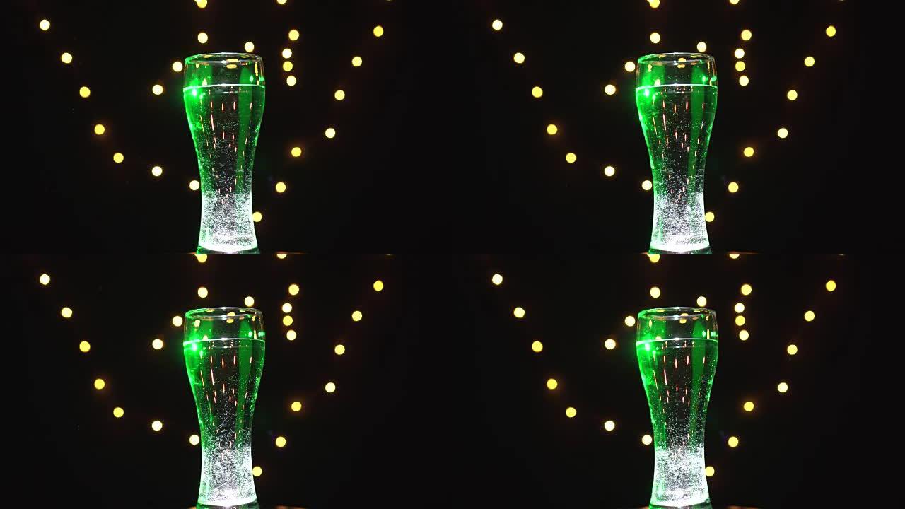 绿灯中的一杯水在旋转。绿色鸡尾酒。酒吧概念