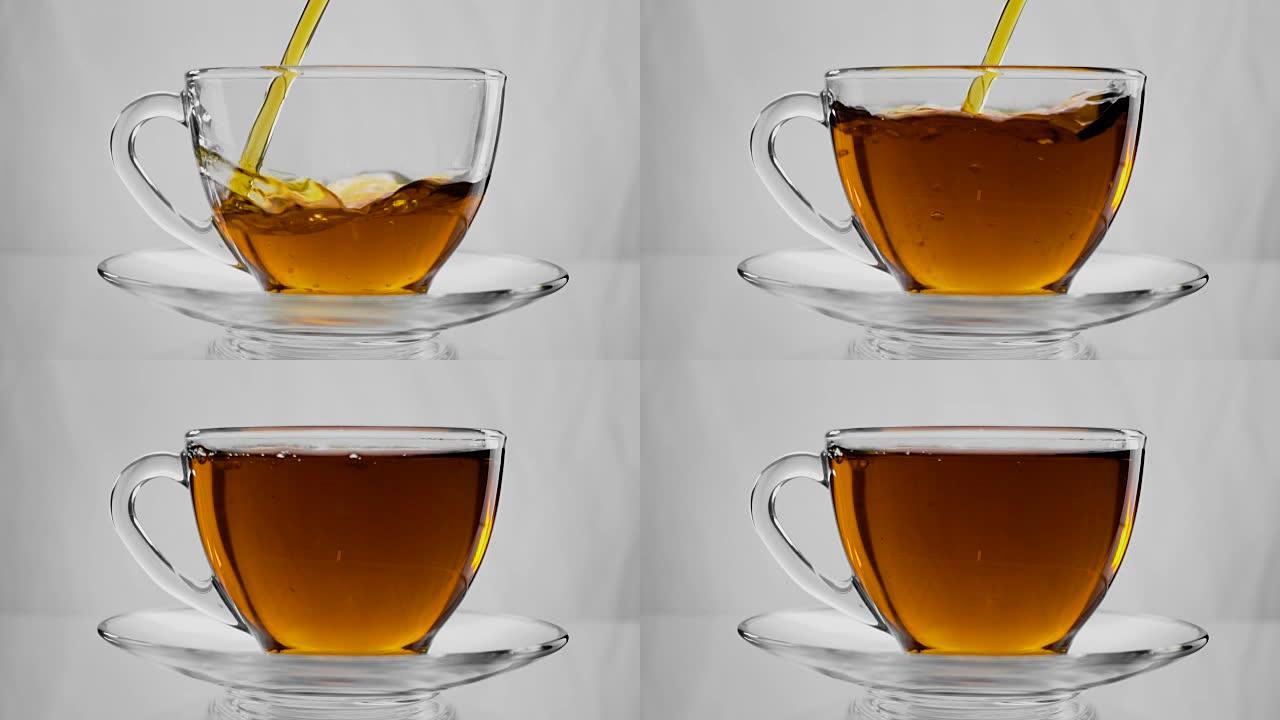 倒茶。将茶倒入玻璃透明茶杯中。喝茶时间。透明玻璃茶壶和茶杯。慢动作