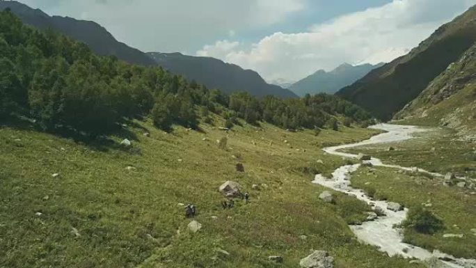 在山上旅行的俯视图游客。沿着山河散步的游客