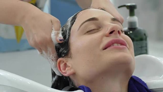 洗头，女人在美容院洗发时享受美发师按摩