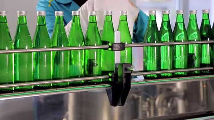 生产线一员工擦绿色玻璃瓶矿泉水
