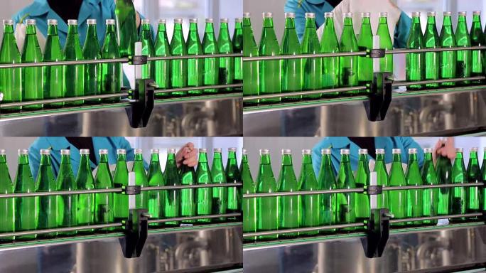 生产线一员工擦绿色玻璃瓶矿泉水