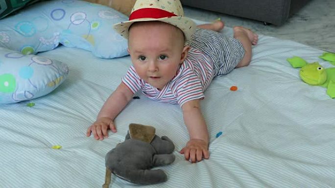 可爱的5个月大男婴，草帽放在游戏垫上