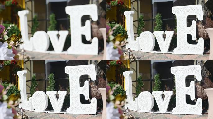 白色大牌子，上面写着爱，站在派对或婚宴旁