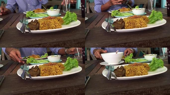 亚洲泰国男子在餐厅吃山羊和山羊一起吃biryani米饭