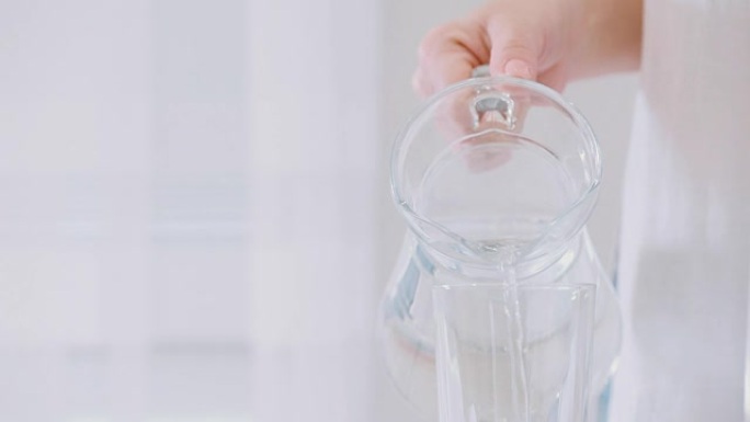 水从水罐倒入玻璃杯中。