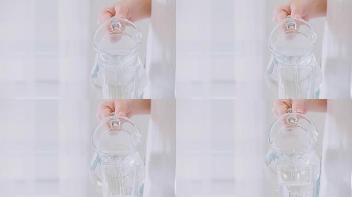 水从水罐倒入玻璃杯中。