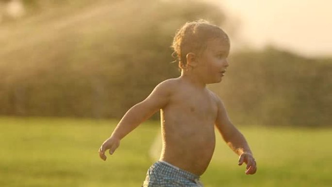 婴儿奔跑在超级慢动作120帧/秒，背景是洒水在日落黄金时间。mov