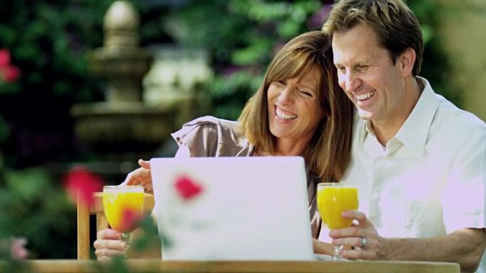 迷人的情侣在笔记本电脑上使用wifi一起微笑