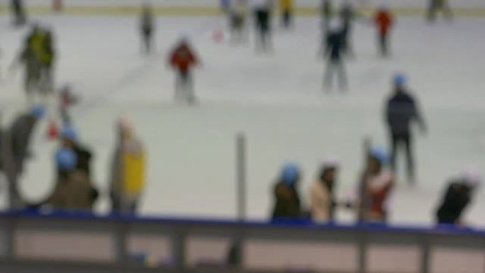 散焦的无法识别的匿名人士正在室内溜冰场上滑冰