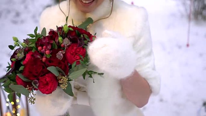 新娘穿着冬衣，手捧一束红玫瑰