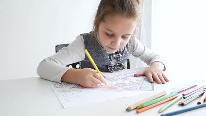 Little girl drawing a picture on white room. 7 yea