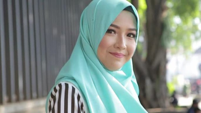 快乐漂亮的穆斯林女人带着头巾微笑