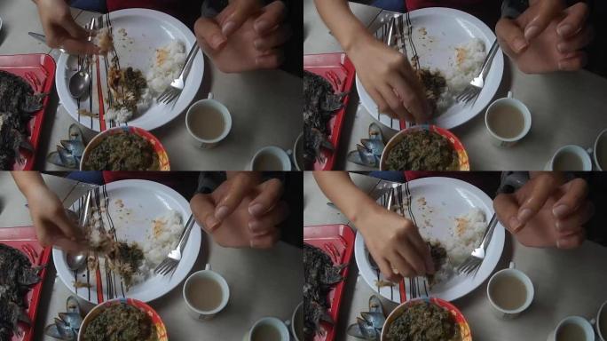 妇女在当地的亚洲竹子餐厅裸露双手吃午餐