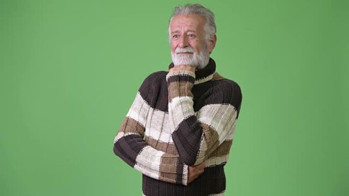 英俊的大胡子男人穿着绿色背景下的保暖衣服
