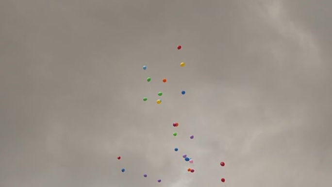 多色充气球在多云的天空背景下飞翔