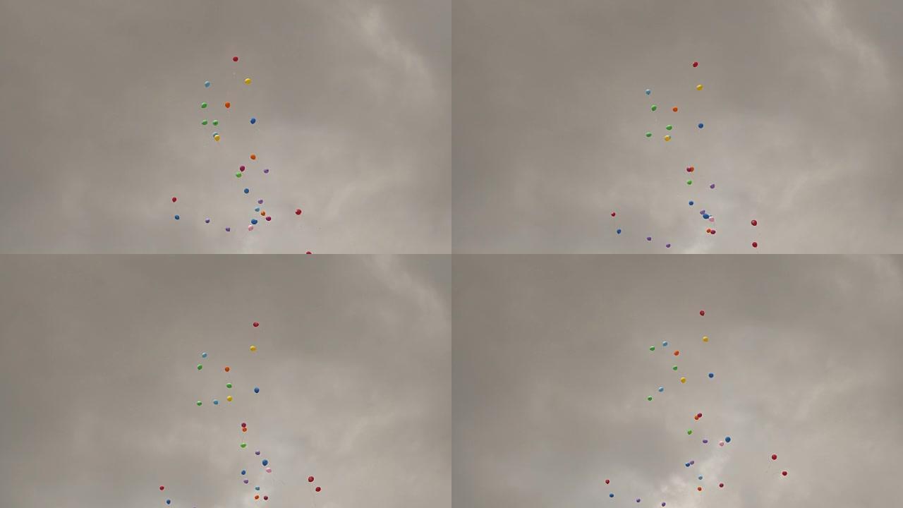 多色充气球在多云的天空背景下飞翔