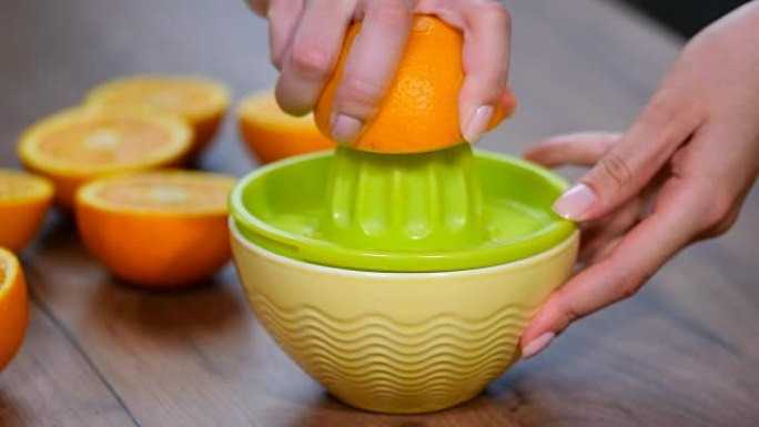 用手动玻璃榨汁机从橙子榨汁的手。